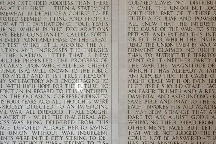 Close-up of engraved text on a stone wall, likely Lincoln Memorial inscription.