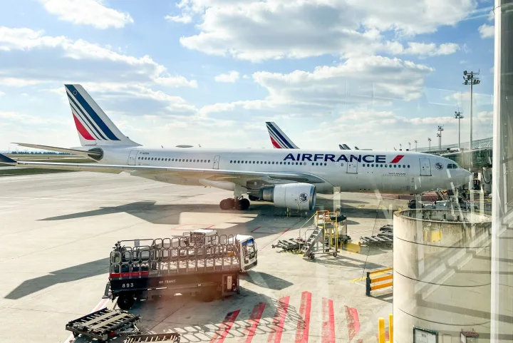 Air France passenger jet parked at an airport gate on a sunny day.