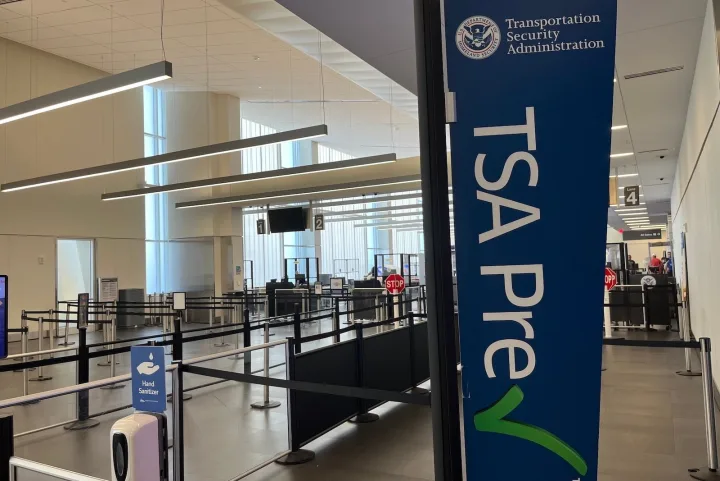 Empty TSA PreCheck security lane at an airport terminal with blue signage.