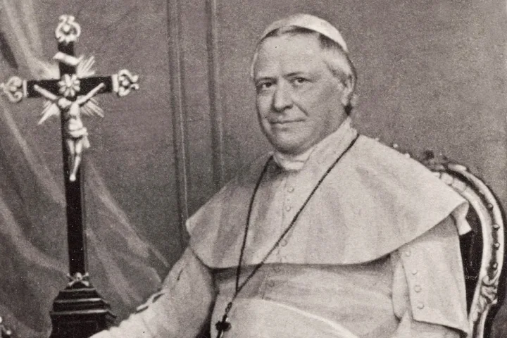 Vintage portrait of a seated Catholic bishop or pope in white robes beside a crucifix.