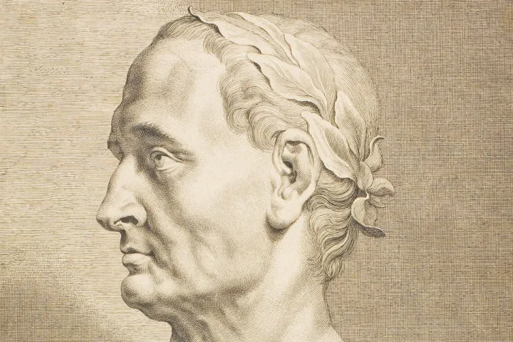 A detailed engraving portrait of Julius Caesar in profile with a laurel wreath.