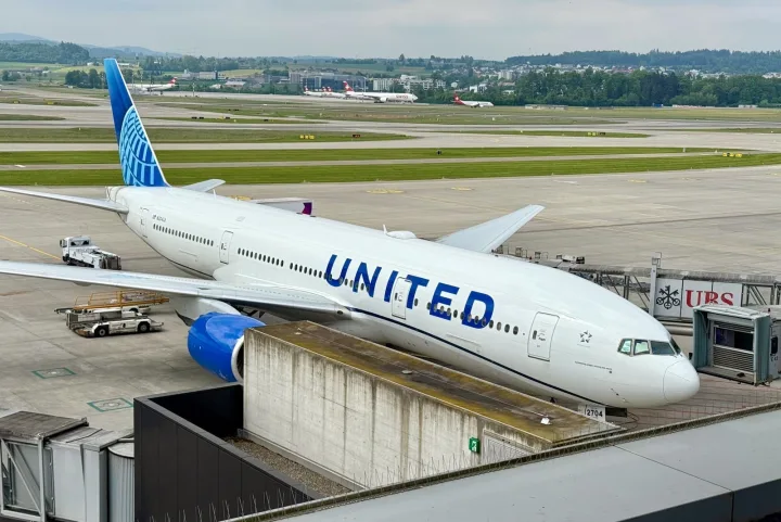 United Airlines wide-body aircraft parked at an airport gate on a cloudy day.