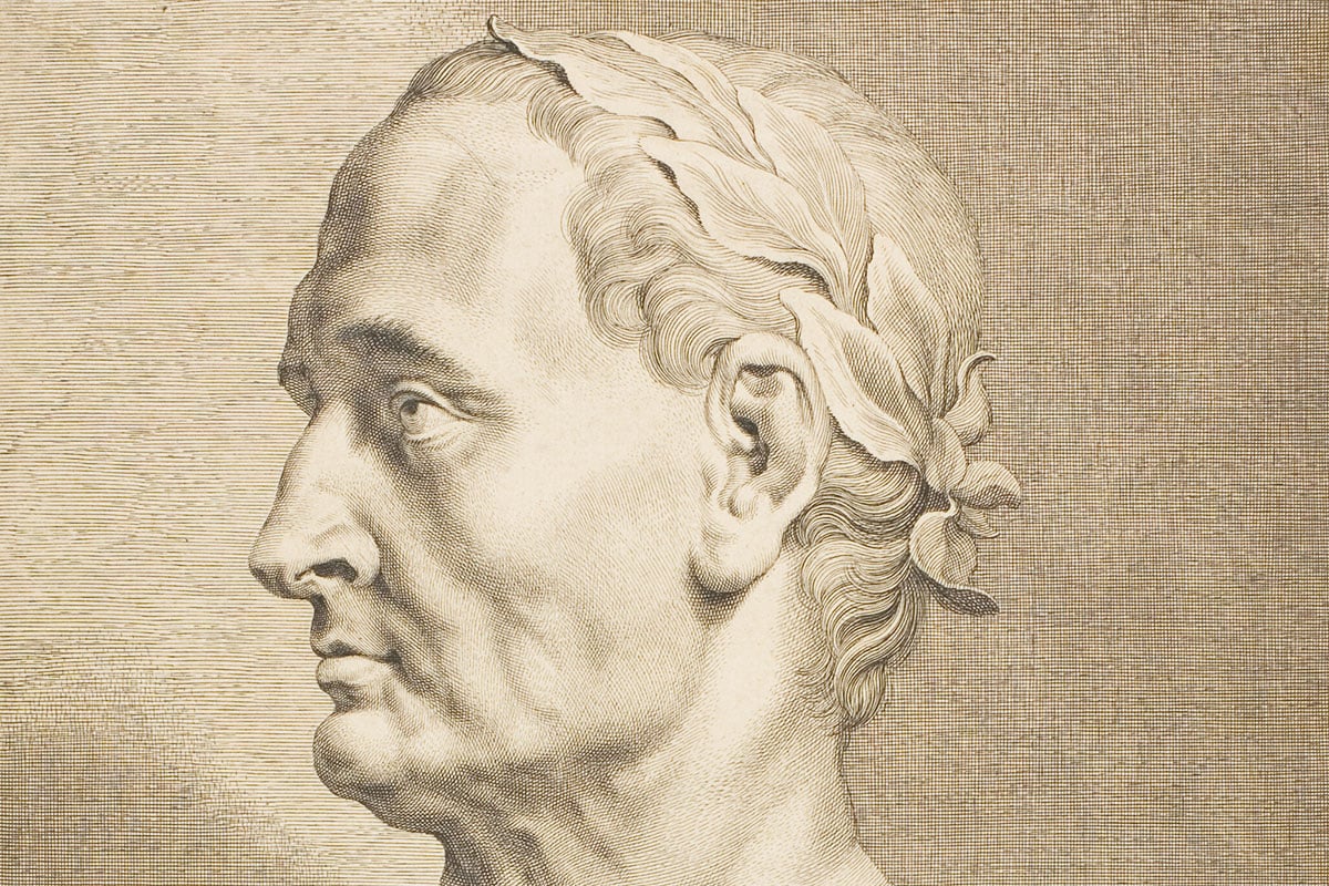 A classical engraving portrait of Julius Caesar in profile wearing a laurel wreath.