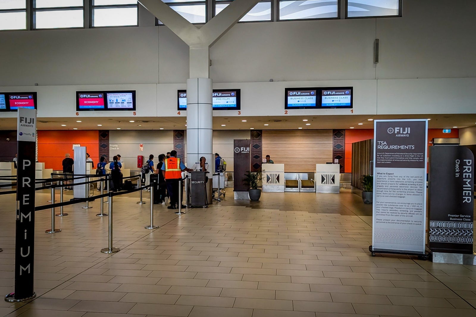 Fiji Airways airport check-in hall showing premium and business class counters with signage.